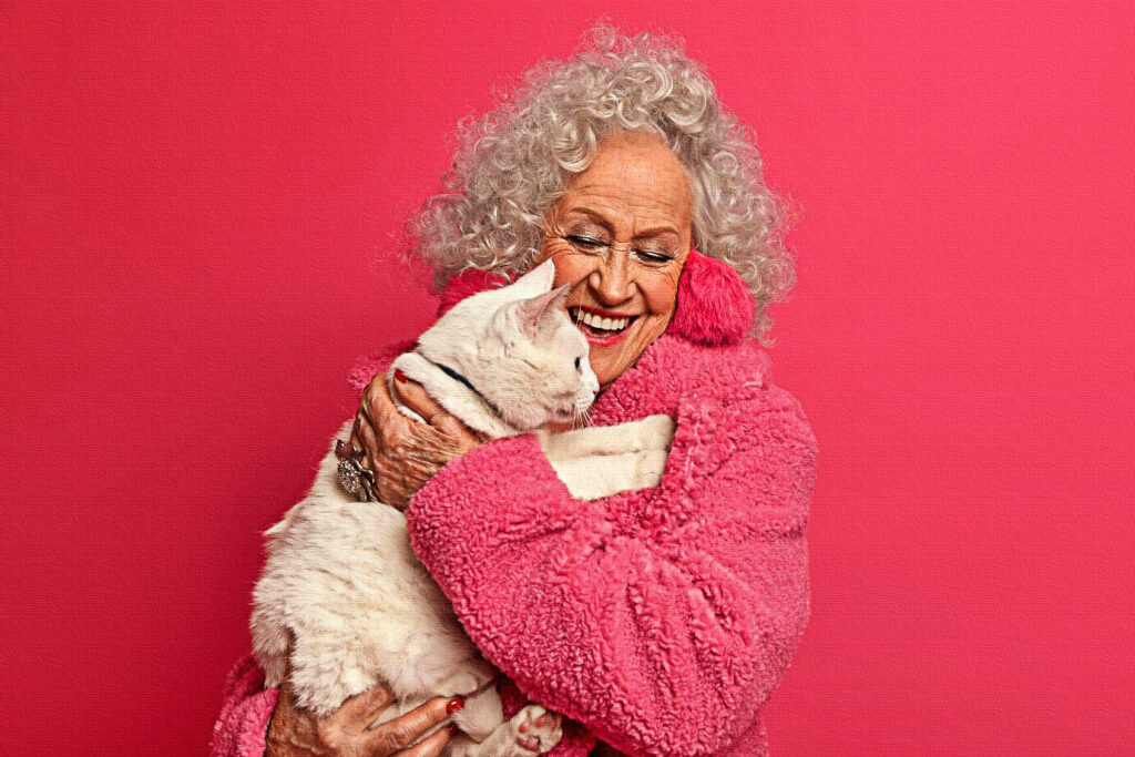 beautiful senior grey haired woman carries white cat